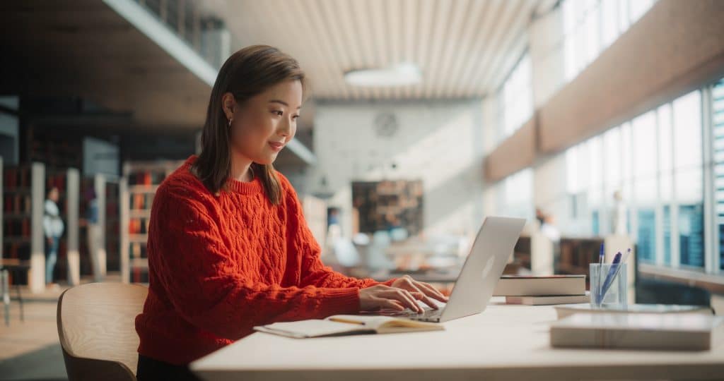 Woman on her computer in a library setting