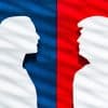 Paper silhouettes of Kamala Harris and Donald Trump in front of blue and red backgrounds, respectively.