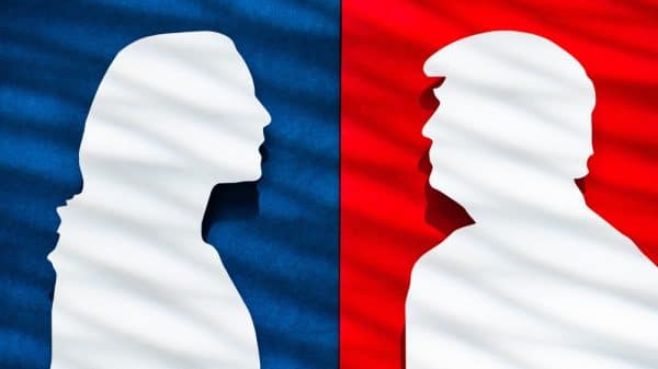 Paper silhouettes of Kamala Harris and Donald Trump in front of blue and red backgrounds, respectively.