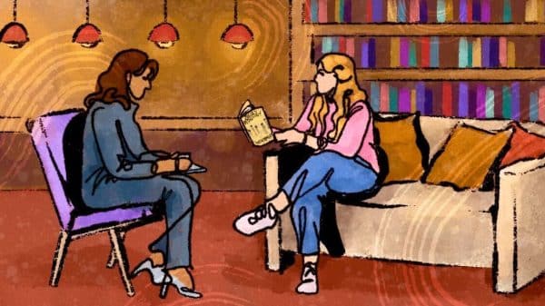 Interviewer and interviewee talking surrounded by books.
