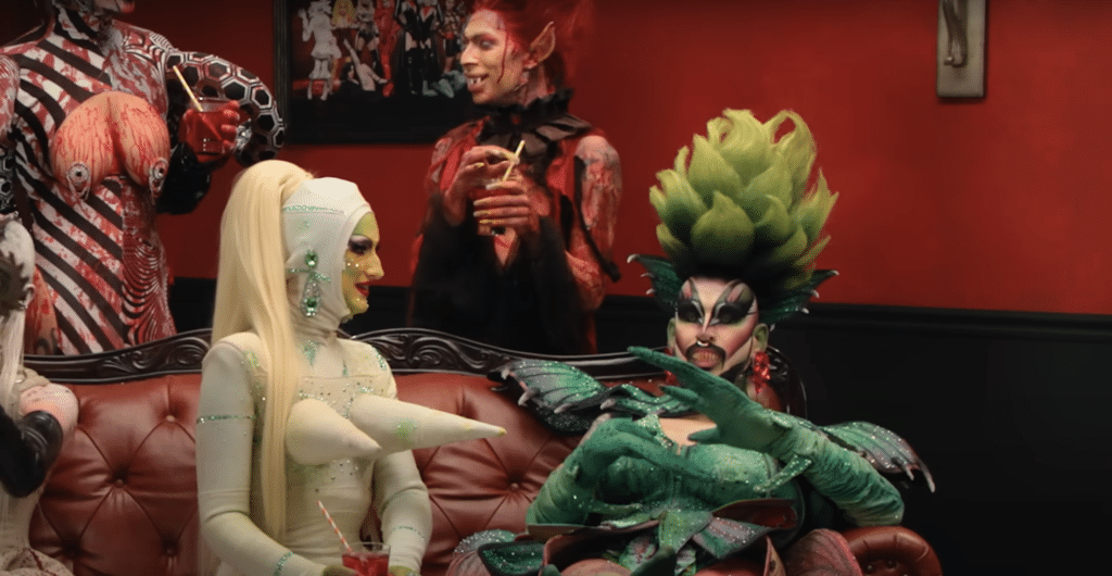 A screenshot of the trailer for Dragula season 6 shows competitors talking after hearing the judges critiques.