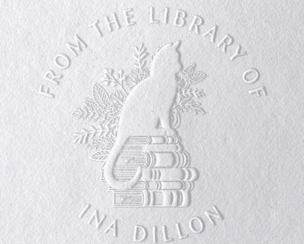 Product image of a Book Embosser on etsy. Design containing a cat sitting on books