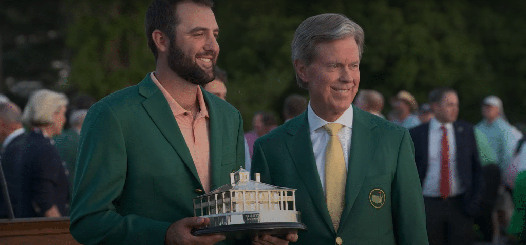 Scottie Scheffler accepting the Masters trophy while wearing his green jacket after winning the 2024 Masters.