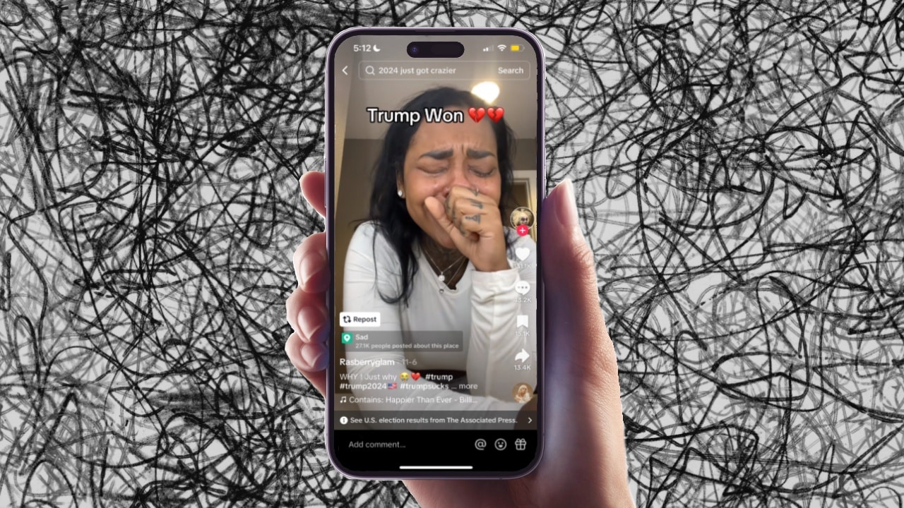 A hand is holding an iphone that is playing a TikTok video of a creator crying at the results of the 2024 election.