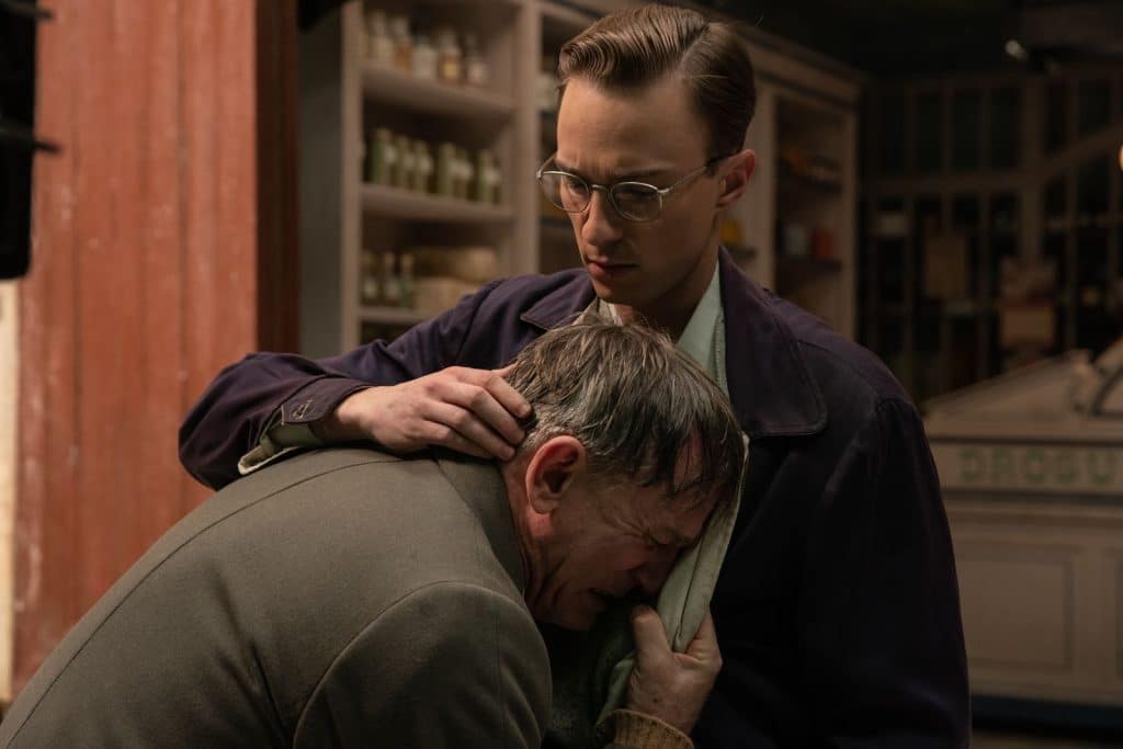 Allerton (Drew Starkey) holding a sobbing Lee (Daniel Craig).