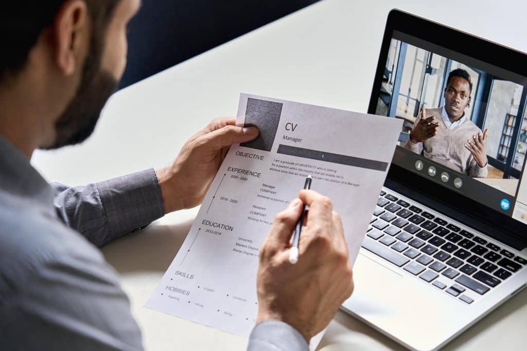 Man looking at his CV while on video call with another man