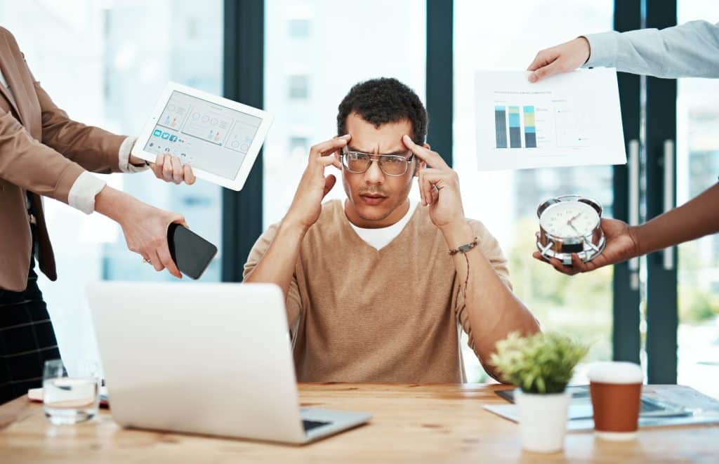 Man stressed with his work showcased through visuals of graphs and clocks