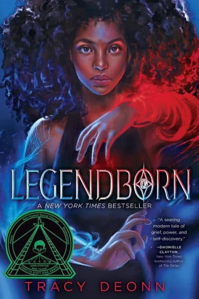 A blue and red book cover featuring a young Black woman with curly hair, glowing blue magic swirling around her right hand and red magic swirls around her left hand. The title "Legendborn" in in the middle of the book in very large letters.