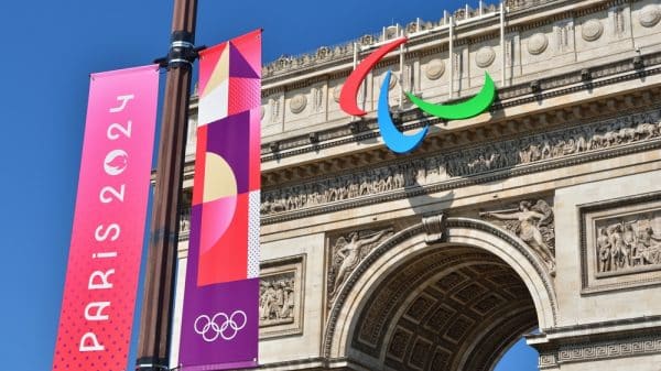 A picture of the Paris 2024 Olympic emblem with L'arc de Triomphe in the background. Credit: Shutterstock/Noriox