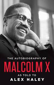 A black and white cover featuring a close-up photograph of Malcolm X smiling, with his name and the title in bold red and white lettering.