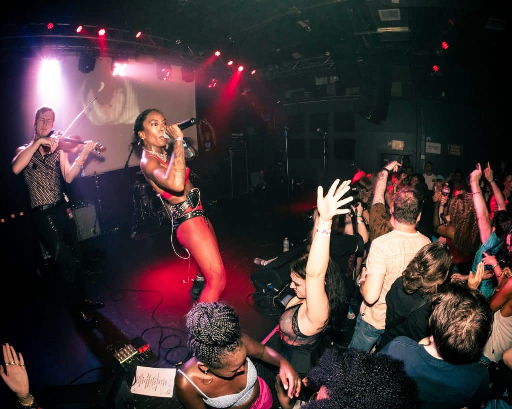 A photo of TeZATalks dancing with the crowd of a music show.