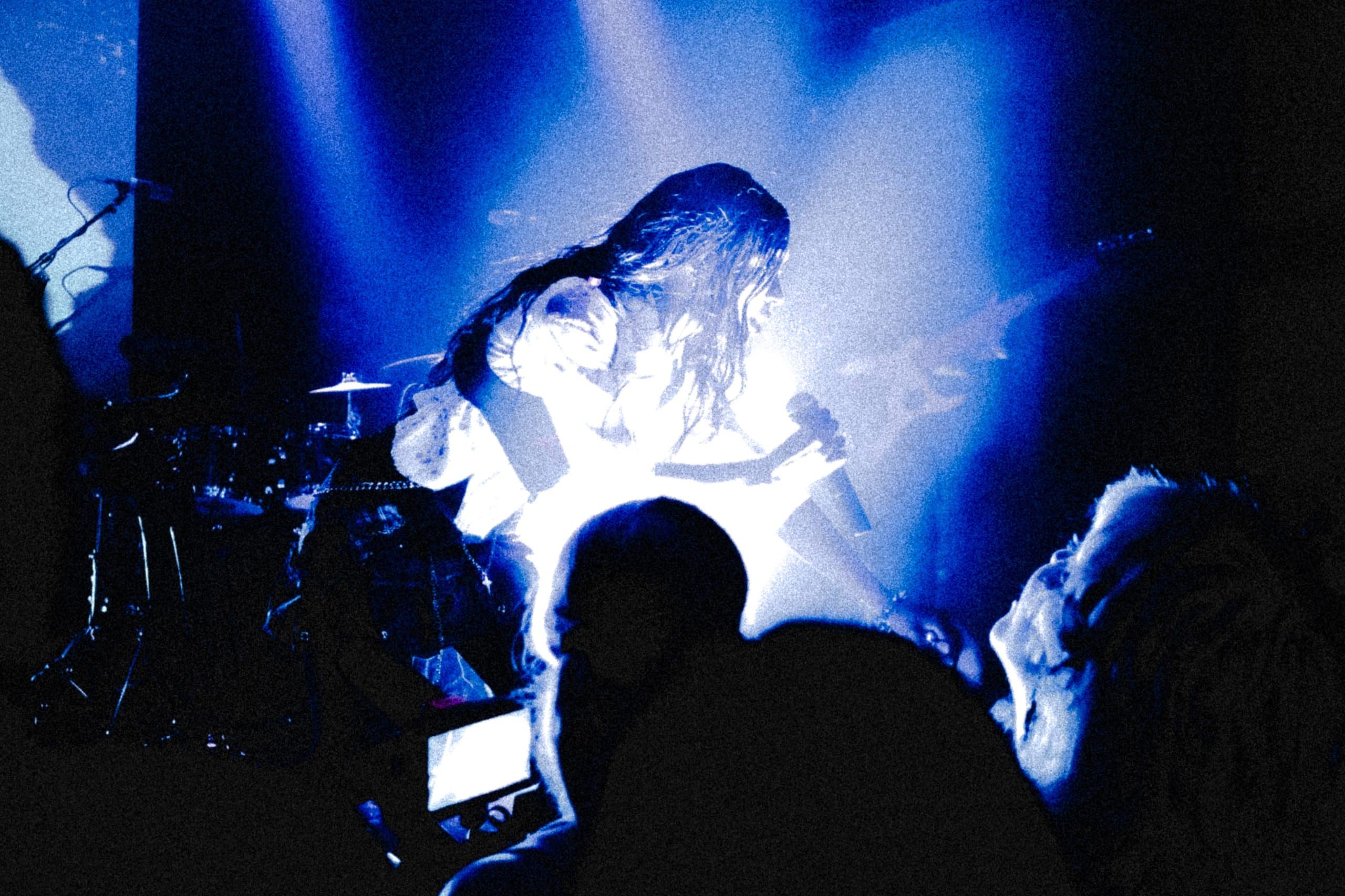 A photo of TeZatalks singing to the crowd at a music show.