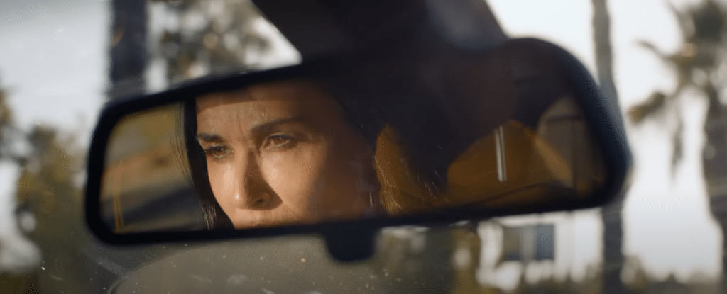 A shot of a woman's (Elisabeth's) face in a rearview mirror