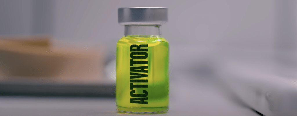 A jar with yellow liquid labeled: ACTIVATOR