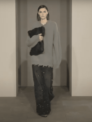 A model in a grey sweater and black jeans at the Simkhai Fall/Winter 2025 New York Fashion Week Show.