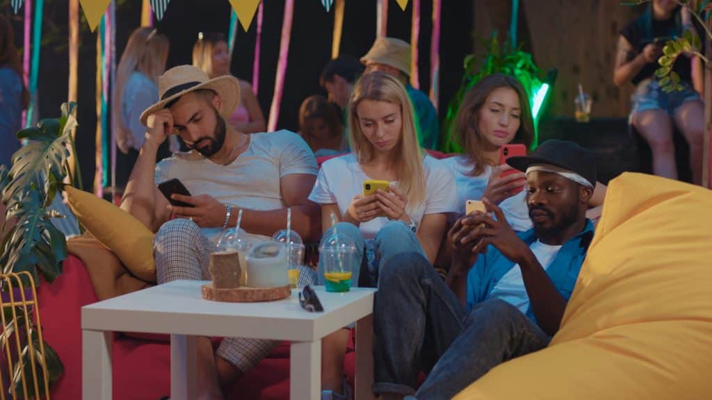 Don't be these people: three people on their phones not talking to each other.