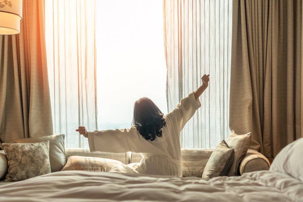 a woman waking up and stretching in the morning