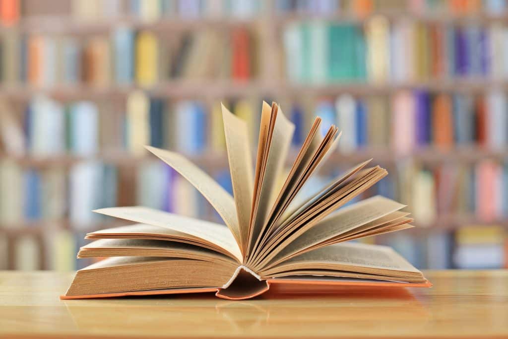 Image of an open book in a library.