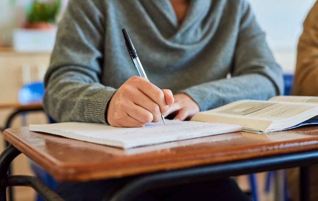 a person writing at a desk