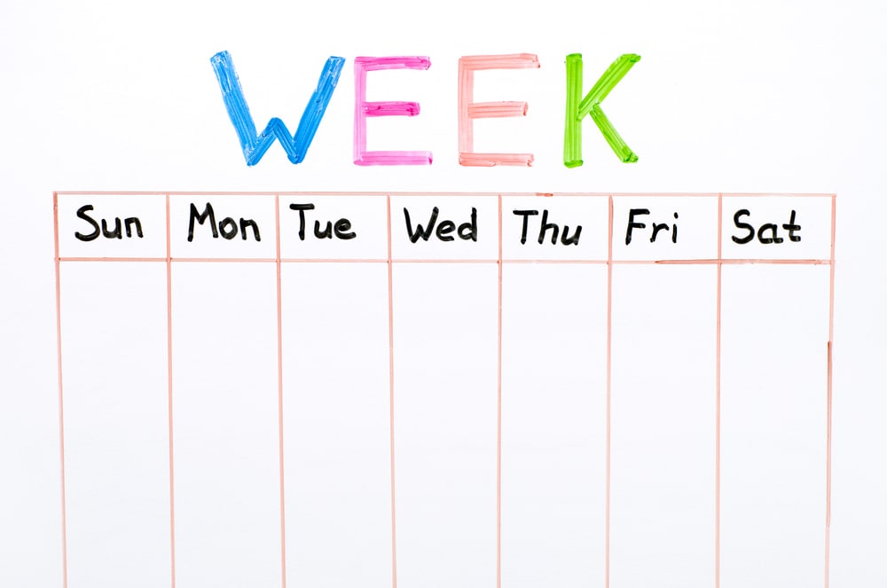 Seven days of the week writing on whiteboard close-up.