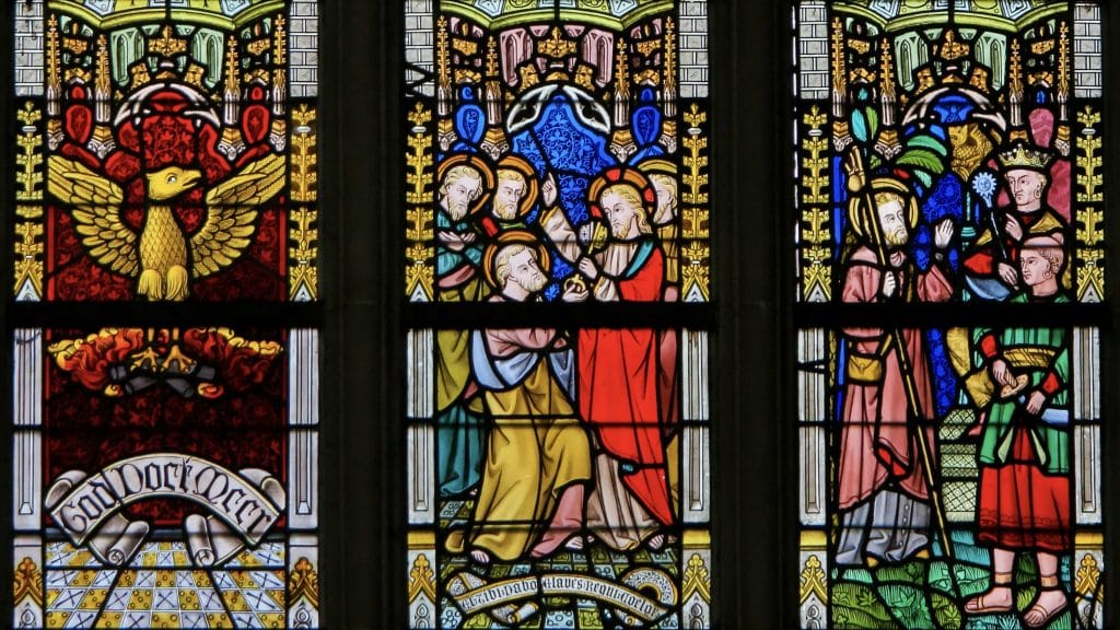 The Cathedral of Saint Bavo in Ghent, Flanders, Belgium: Stained glass window depicting a phoenix, Jesus Christ, Saint Peter, and a Belgian Roman Catholic missionary. Image: Shutterstock/Jorisvo