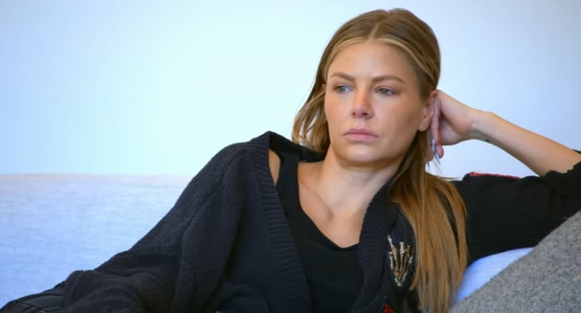 Ariana Maddix sitting on her couch looking heartbroken