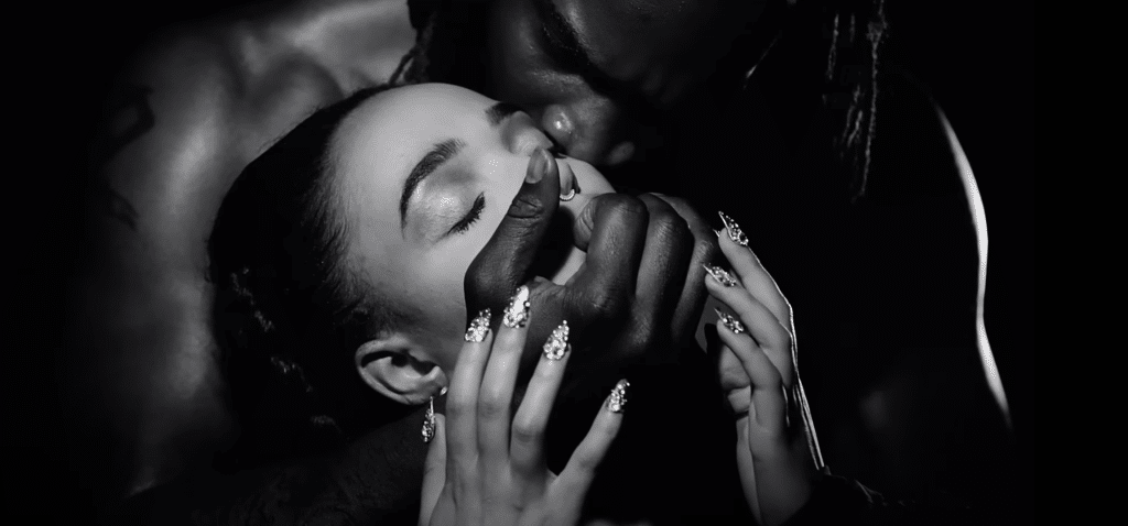 A man covers FKA Twigs mouth