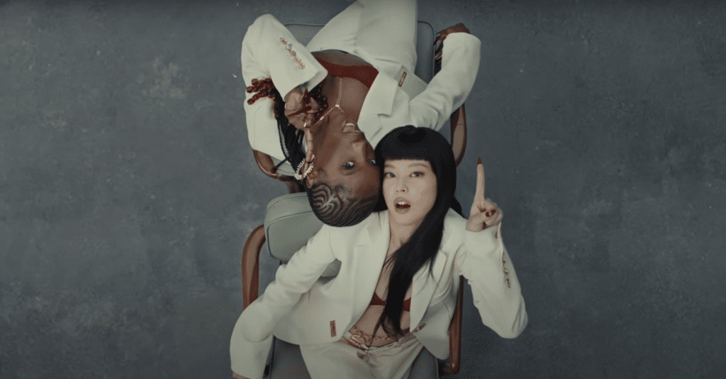 A screenshot of Doechii and JENNIE sitting side-by-side in the "ExtraL" music video.