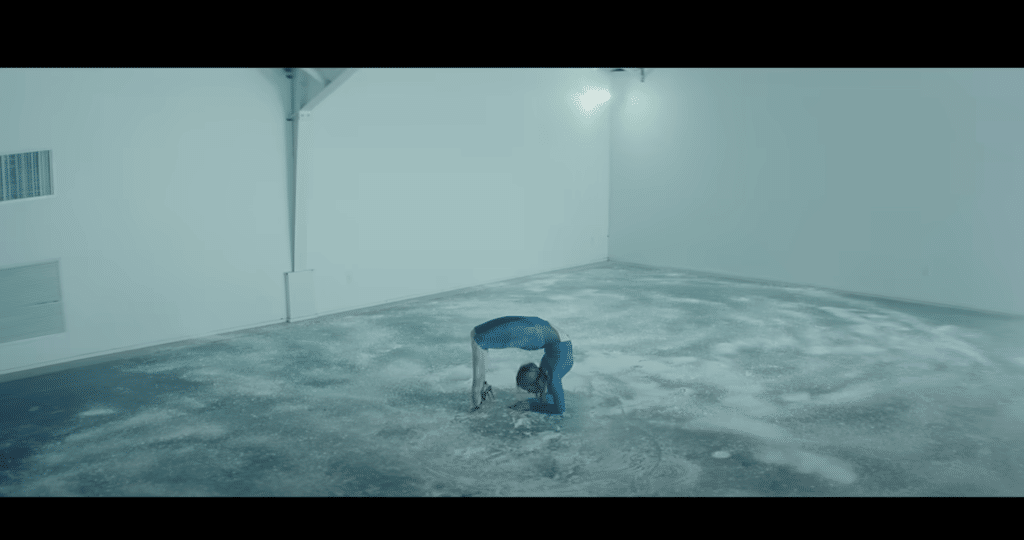 A screenshot of Addison Rae bending over a floor of powered sugar in the "High Fashion" music video.