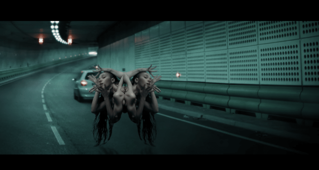 A screenshot of FKA Twigs morphing into a creature in the "Striptease" music video.