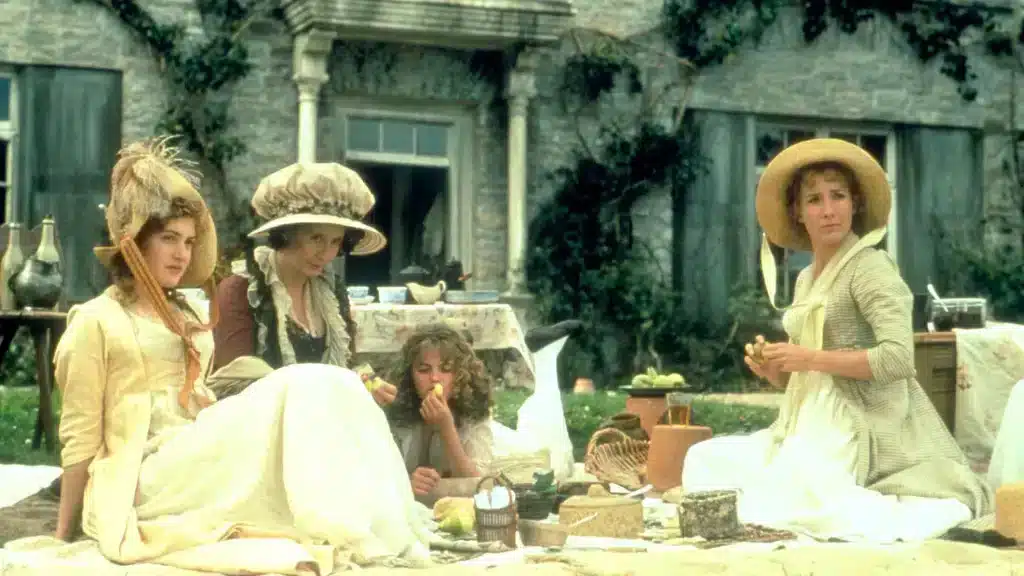 Must-Watch Movies for English Majors: Sense & Sensibility - Emma Thompson, Kate Winslet, and others at a picnic staring at something off-screen