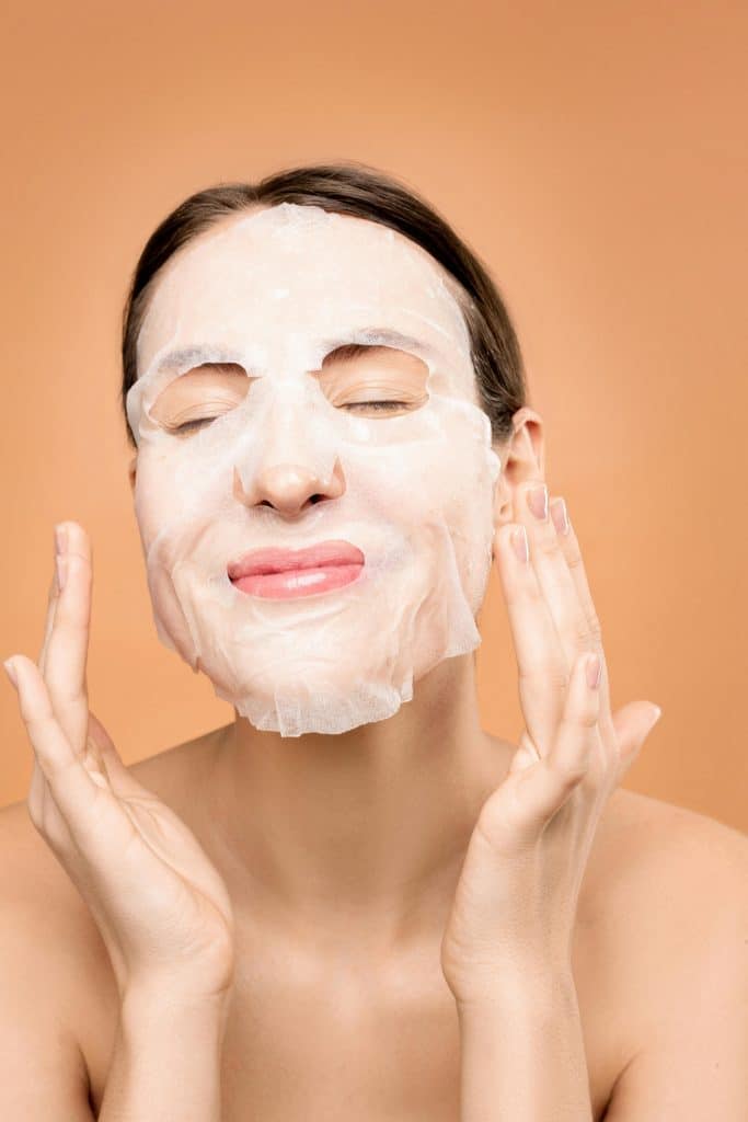 a girl wearing a sheet mask while smiling