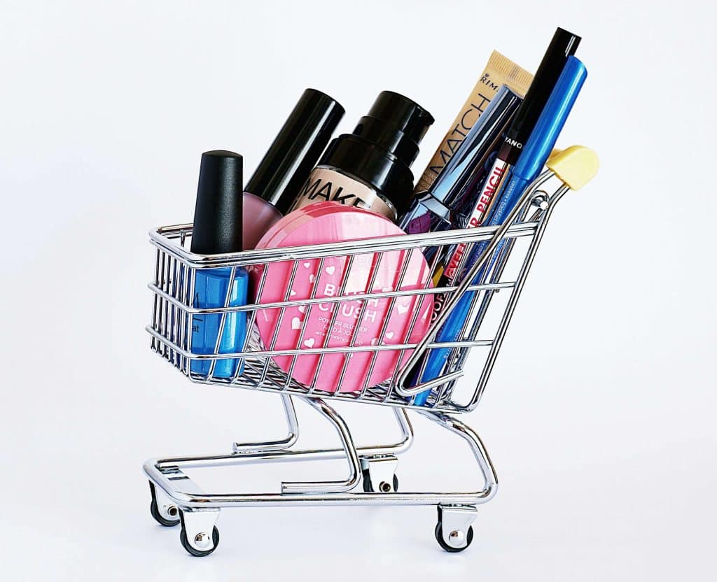 Mini shopping cart full of different makeup products