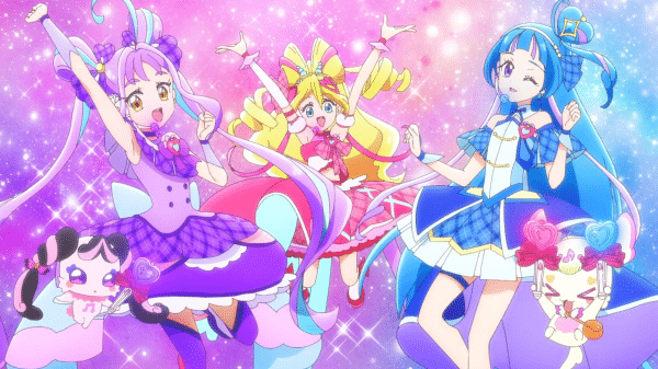 From left to right, Cure Kyun-Kyun, Cure Idol, and Cure Wink jumping against a sparkly background.