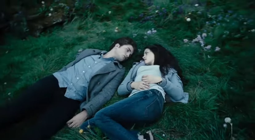 Edward and Bella laying in a field, staring at each other
