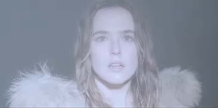 Woman stares into headlights with a grim expression