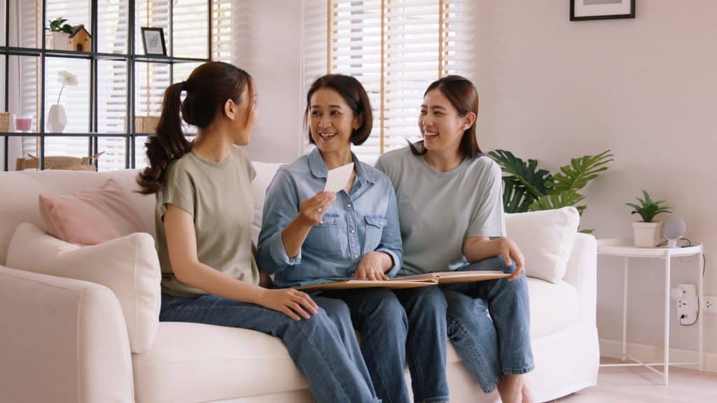 Two daughters in their 20s and 30s talking to their mom about their lives.