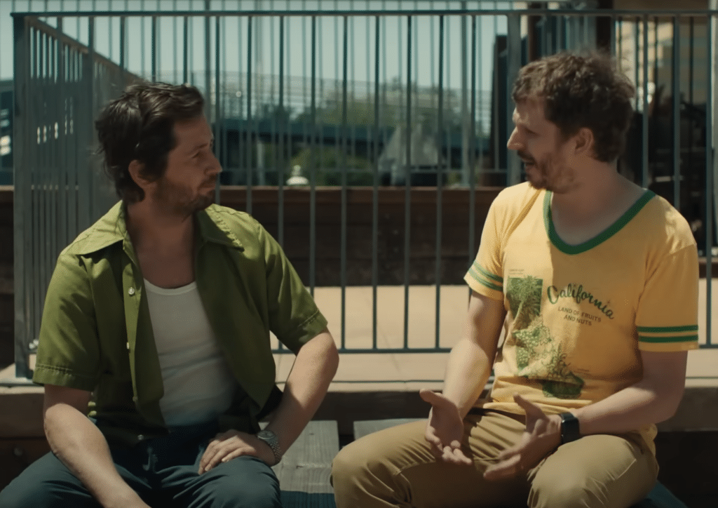 Left to right: Michael Angarano, Michael Cera conversing on a balcony