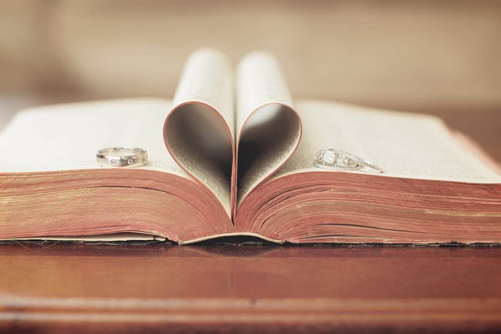An open book with two pages folded to form a heart shape in the middle.
