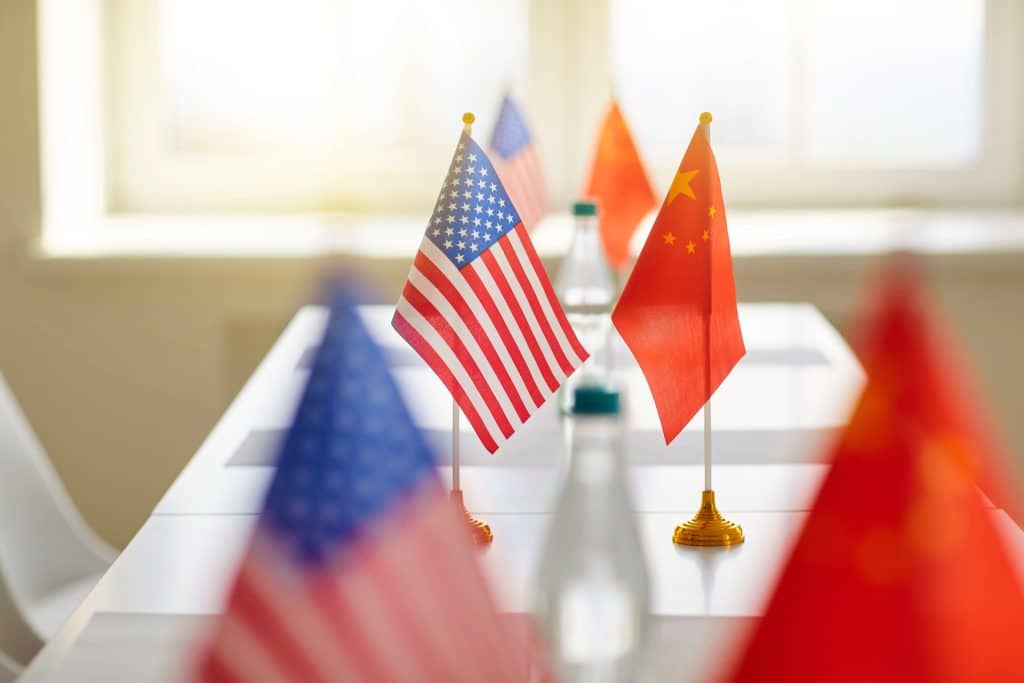 U.S. and Chinese flags on desks face eachother.