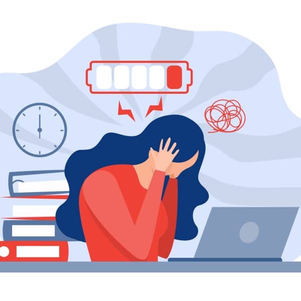 A woman suffering from burnout sits at her desk with her head in her hands, surrounded by a ticking clock with a low battery over her head