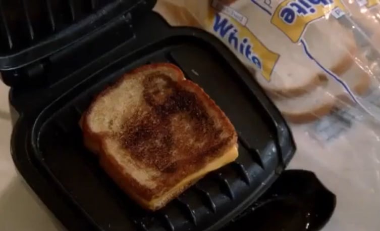 A grilled cheese sandwich with a burn mark that resembles Jesus.