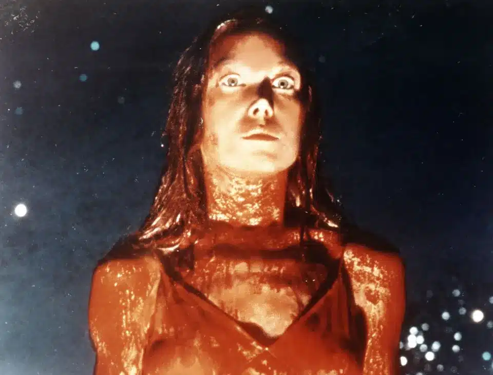 Sissy Spacek frozen in shock and anger, covered in blood.
