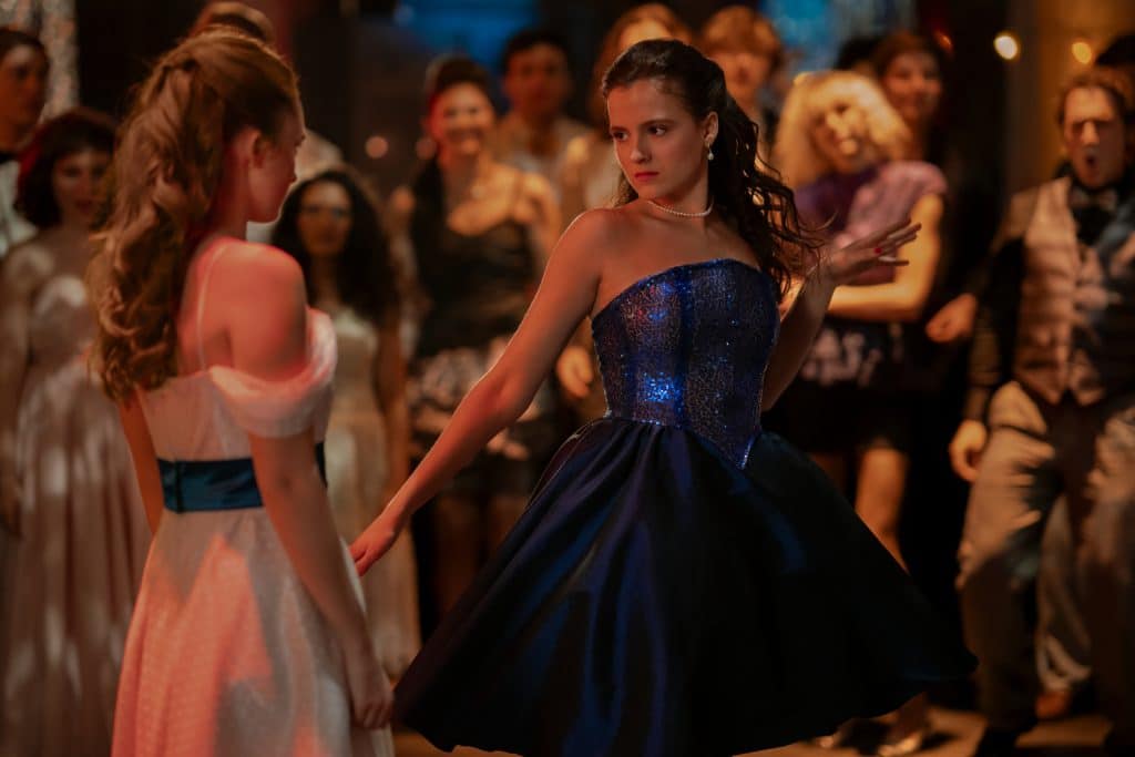 India Fowler in flowy white dress with blue detailing, and Fina Strazza in sparkly blue strapless dress in a dance-off.