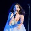 Lorde performing on stage in blue dress