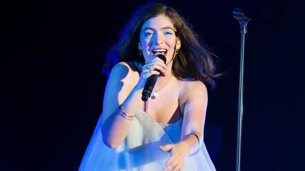 Lorde performing on stage in blue dress