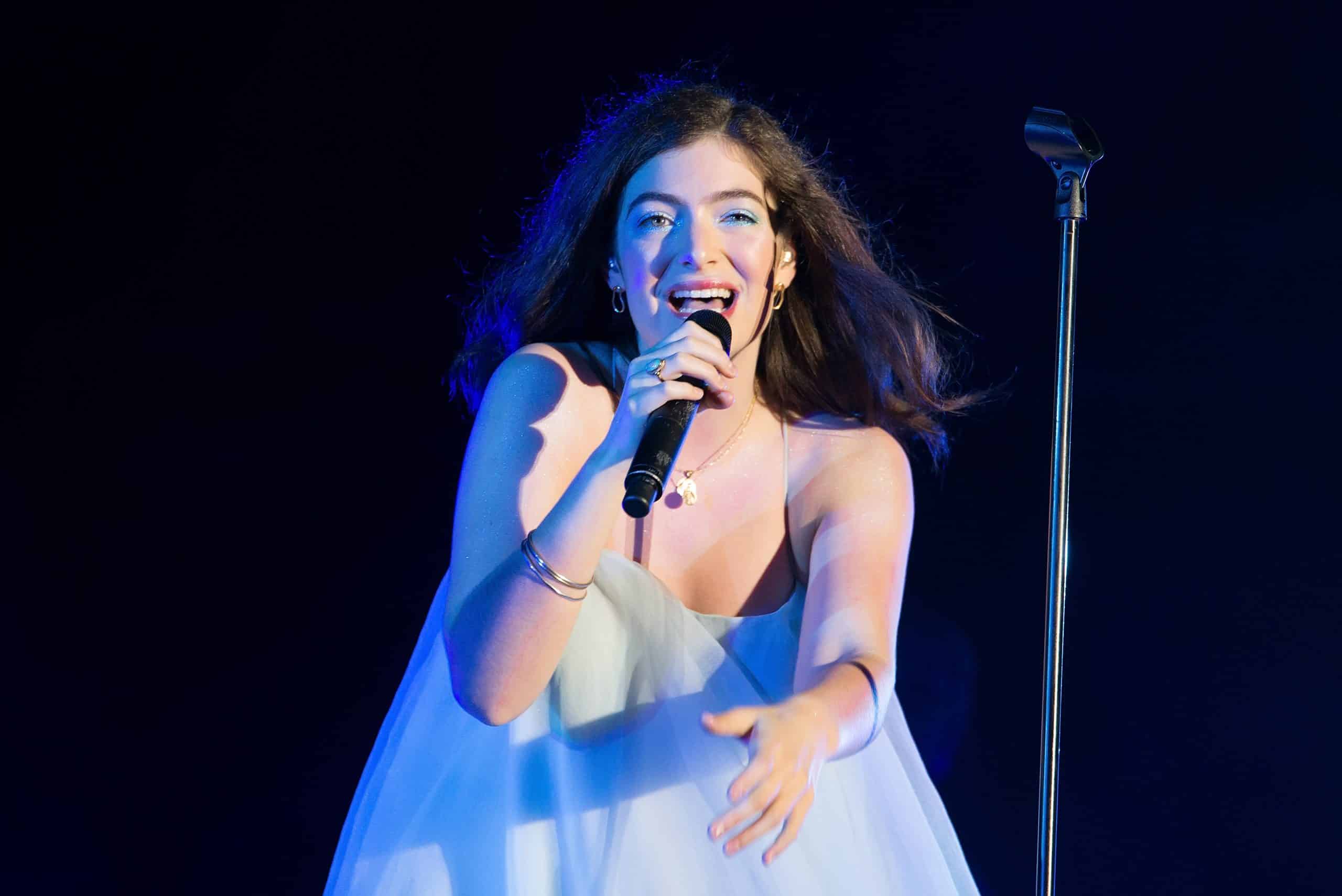 Lorde performing on stage in blue dress