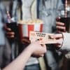 Person handing two movie tickets over to another person.