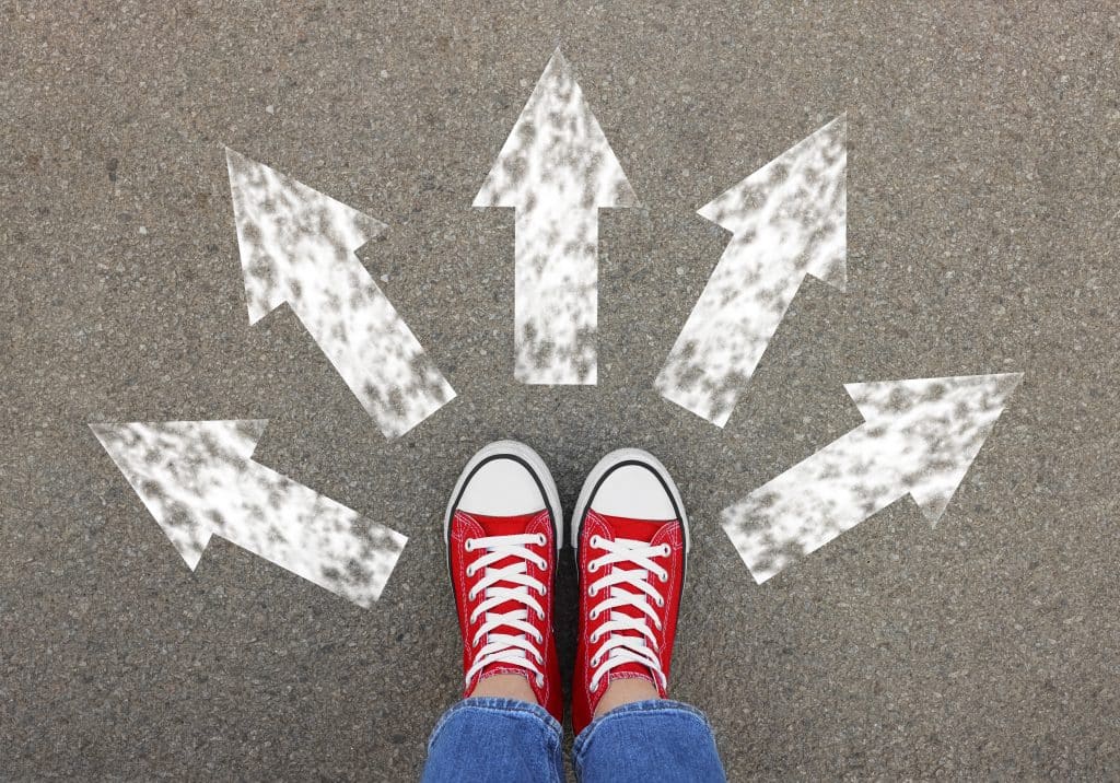 Two feet pointing towards five arrows going different directions: how do we take the next step in life after college