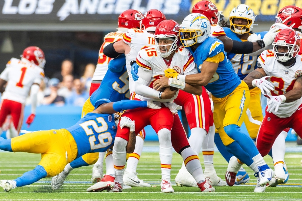 Chiefs quarterback Patrick Mahomes spins around and tries to break a tackle in a game against the Los Angeles Chargers.